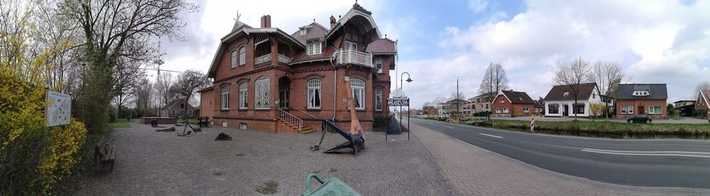 Panoramic view of buildings and street in city against sky