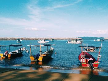 Boats moored on sea against sky