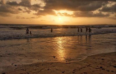 People on beach at sunset