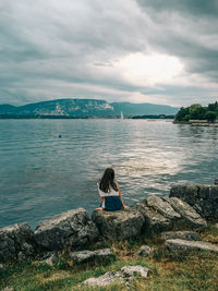 Rear view of woman sitting on beach