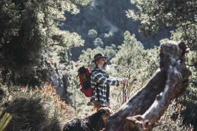 Bearded man hiking with his dog in the mountains. person