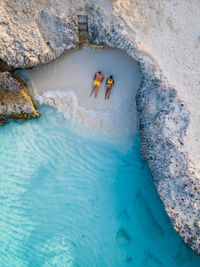 High angle view of people on rock by sea