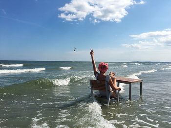 Men sitting at beach against sky