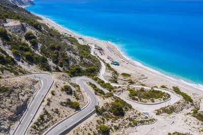 High angle view of road by sea against blue sky