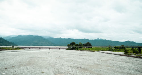 Road leading towards mountains against sky