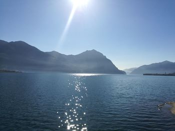 Scenic view of sea and mountains against clear sky