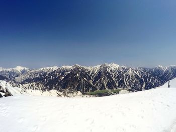 Snow covered mountain against blue sky