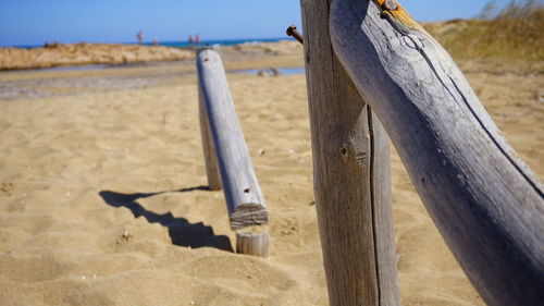 Close-up of wooden post at beach against sky