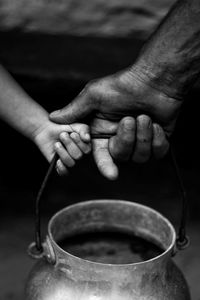 Cropped image of child and man holding container