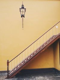 Staircase against yellow wall in building