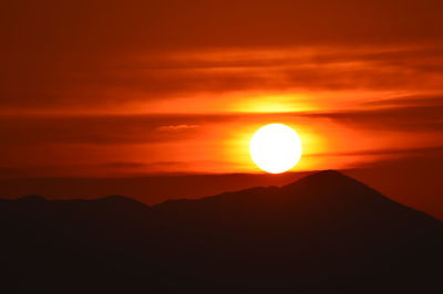 Scenic view of silhouette mountain against orange sky