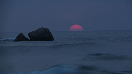 Scenic view of rocks in sea against sky