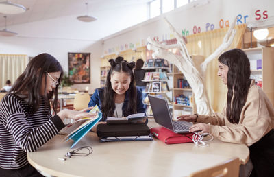 Teenage girls sitting together in library