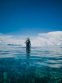 Man swimming in sea against sky