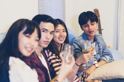 Portrait of friends enjoying champagne during celebration at home