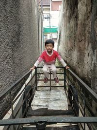 Portrait of woman standing against railing