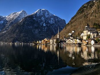 Buildings by mountains against sky during winter