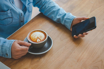 Midsection of coffee cup on table