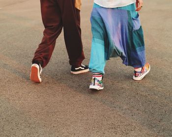 Low section of men walking on road