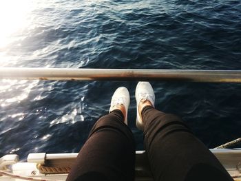 Low section of man sitting on boat against sea