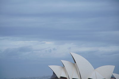 Low angle view of white building against cloudy sky