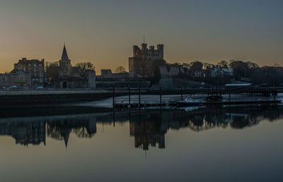 Reflection of buildings in city at sunset