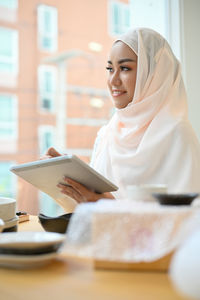 Young businesswoman in hijab packing parcels