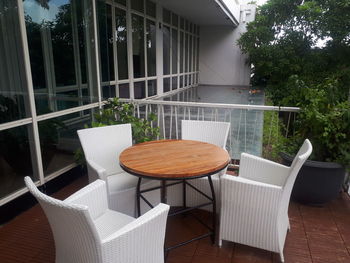 Empty chairs and table against building