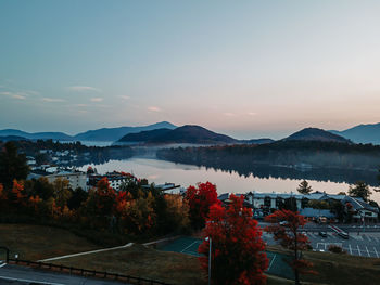 High angle view of city by mountains against sky during sunset