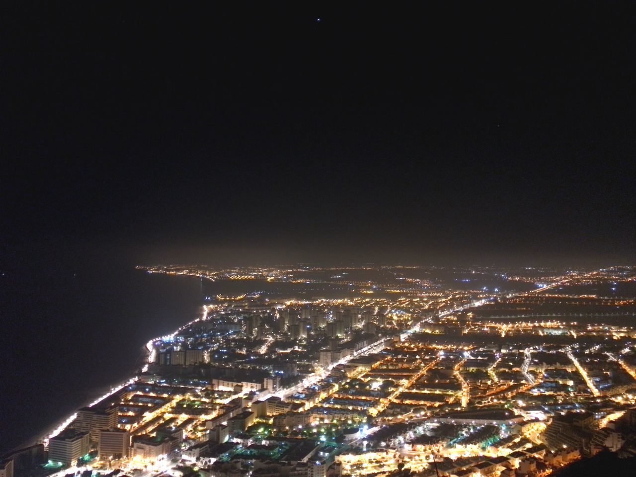 HIGH ANGLE VIEW OF ILLUMINATED BUILDINGS AT NIGHT