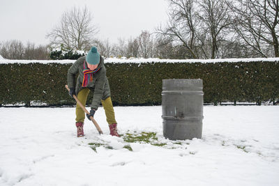 Rear view of woman standing on snow covered field