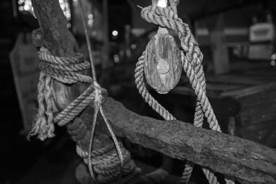 Close-up of old rope and ship's rigging rope tied to wooden post