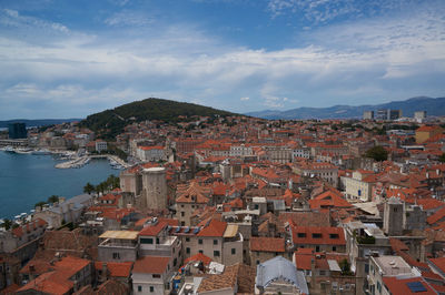 High angle view of townscape by sea against sky