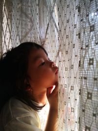 Close-up portrait of a girl looking away against wall