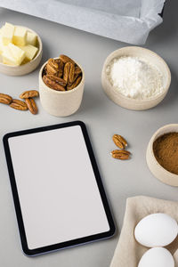 Close-up of brownie ingredients and tablet on a gray surface in the modern kitchen. culinary blog.