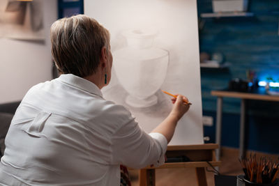 Senior woman drawing on canvas