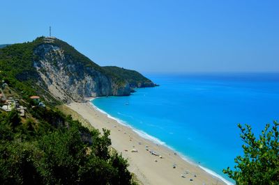 High angle view of cliff by beach against clear sky