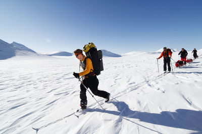 Tourists cross country skiing in mountain scenery