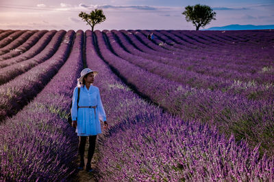 Full length of woman standing on flowering plants