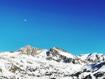 Scenic view of snowcapped mountains against clear blue sky