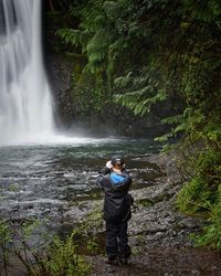 Man photographing waterfall