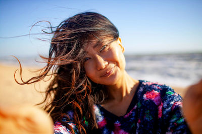 Close-up of young woman looking away at beach