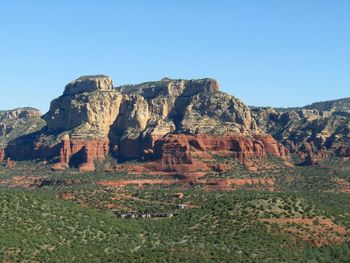 Rock formations on mountain against clear blue sky