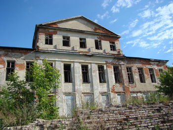 Low angle view of abandoned building against sky