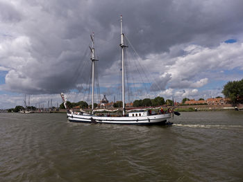 Boats sailing on river against sky