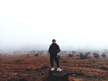 Full length of man standing on landscape against sky