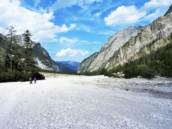 Rear view of road amidst mountains against sky