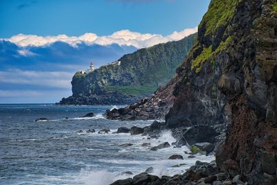 Scenic view of sea against sky with lighthouse 