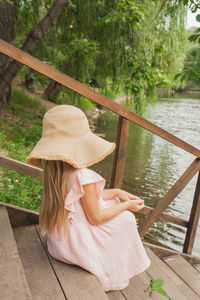 Full length of woman sitting on railing