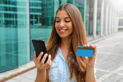 Beautiful young woman using mobile phone